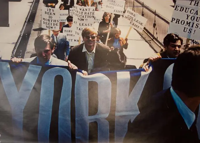 faculty, students, and staff march across the BK bridge in support of college