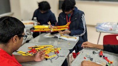 Students building a plane out of legos
